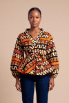 Haut wax africain Oumou portefeuille motif graphique brun et orange manches bouffantes